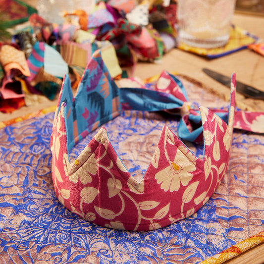 Decorative fabric christmas crown on a table with colorful materials in the background