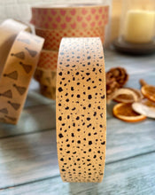 Load image into Gallery viewer, a photo of some brown kraft sticky tape with black spots on it that look like dalmation pattern
