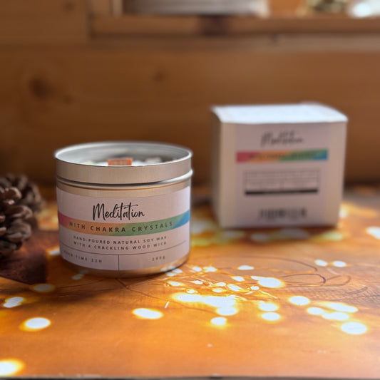 Candle labeled 'Meditation with Chakra Crystals' on a wooden surface